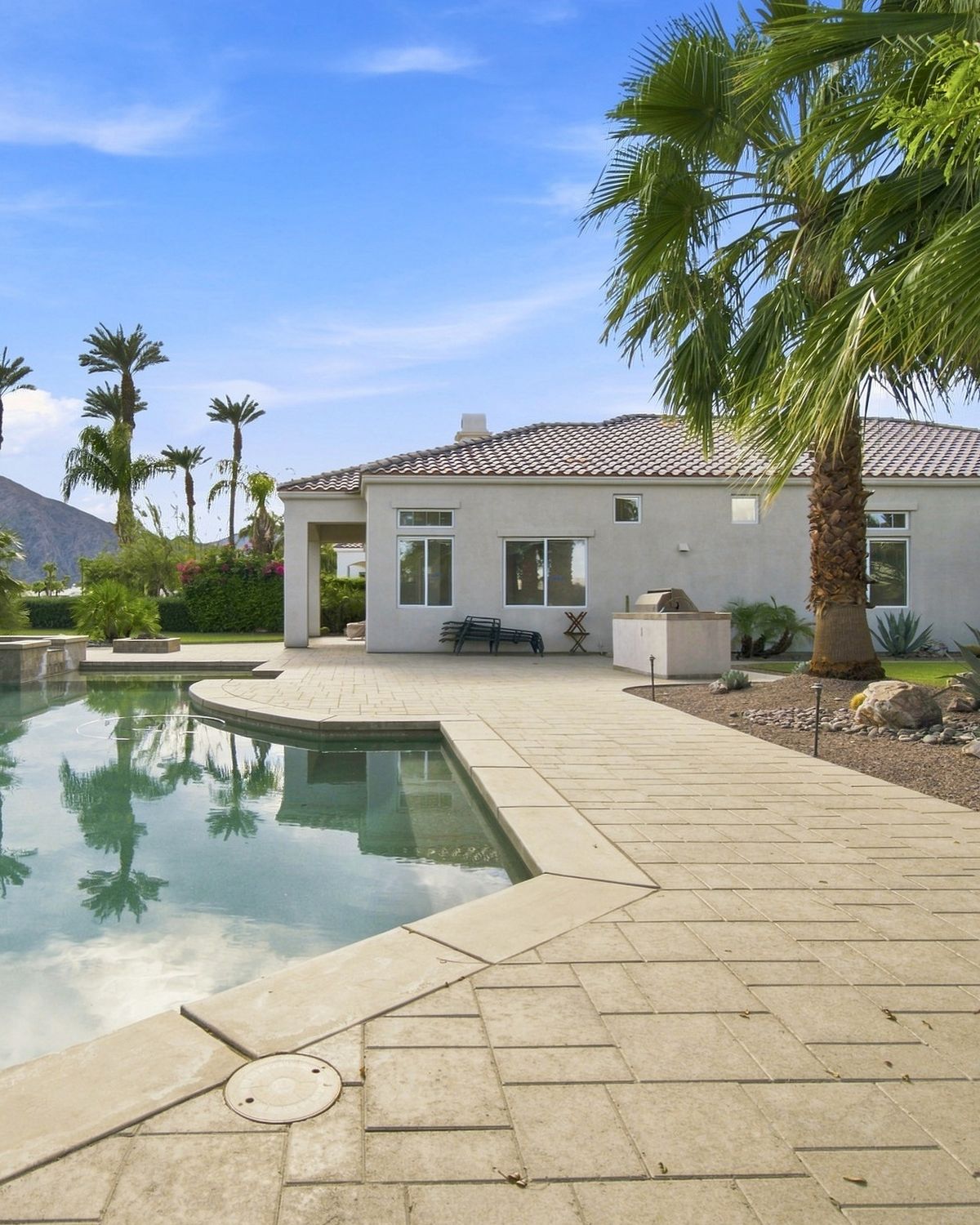 Backyard pool with palm trees, paver patio and mountain backdrop