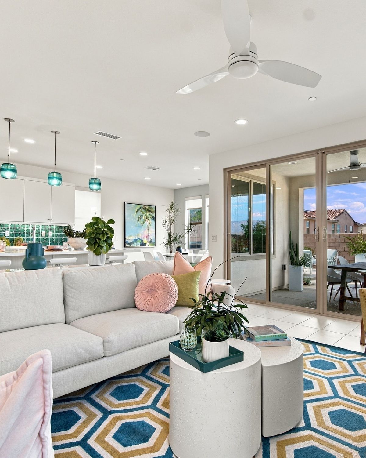 Living room with white sectional, geometric rug and open kitchen beyond