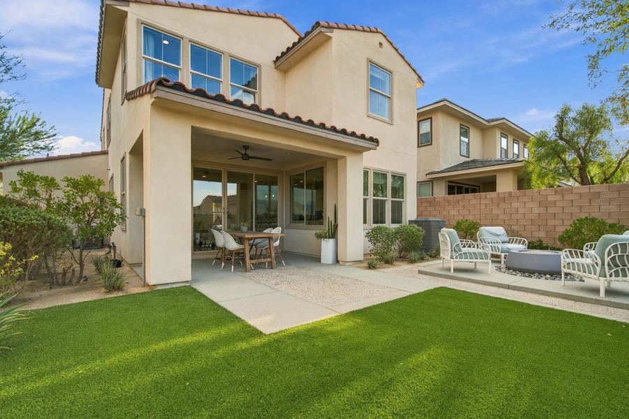 Backyard with covered patio, turf lawn and fire pit seating