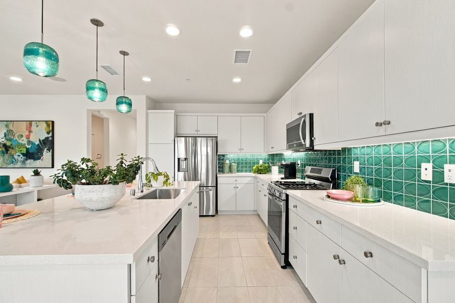 Kitchen with teal tile backsplash and stainless appliances