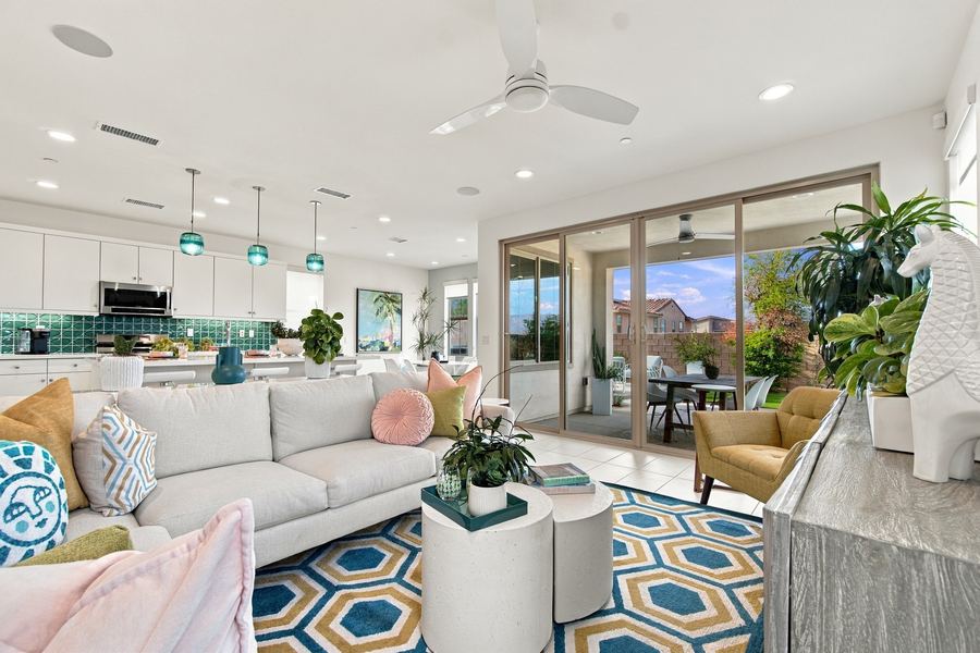 Living room sectional with open kitchen and teal pendant lights