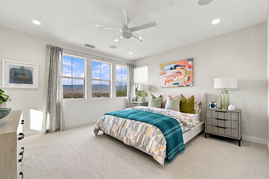 Primary bedroom with patterned bedding and mountain view windows