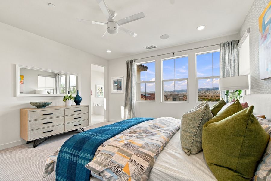 Primary bedroom with dresser, mirror and mountain view windows