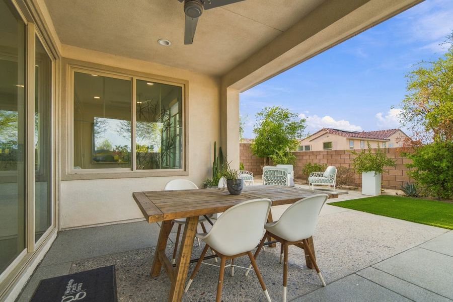 Covered patio dining area overlooking the backyard